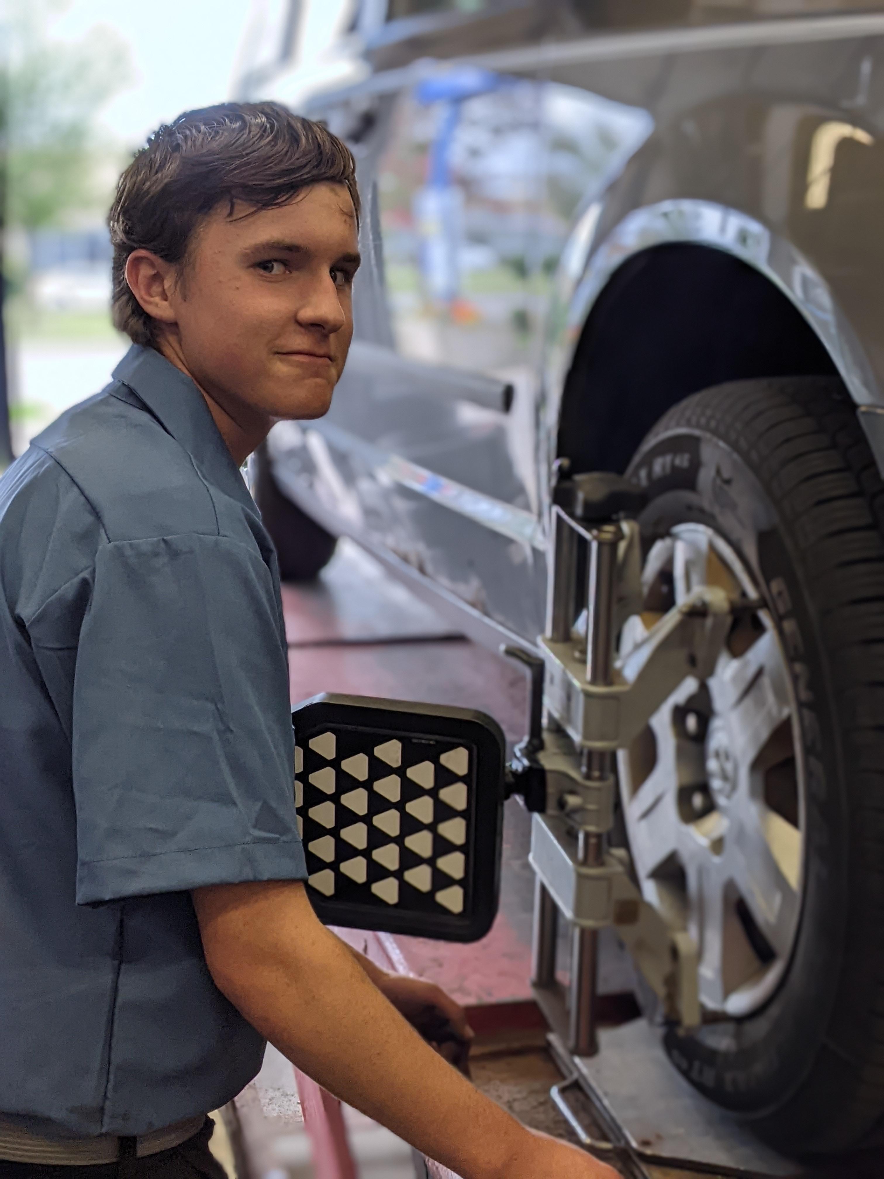 student working on car tire