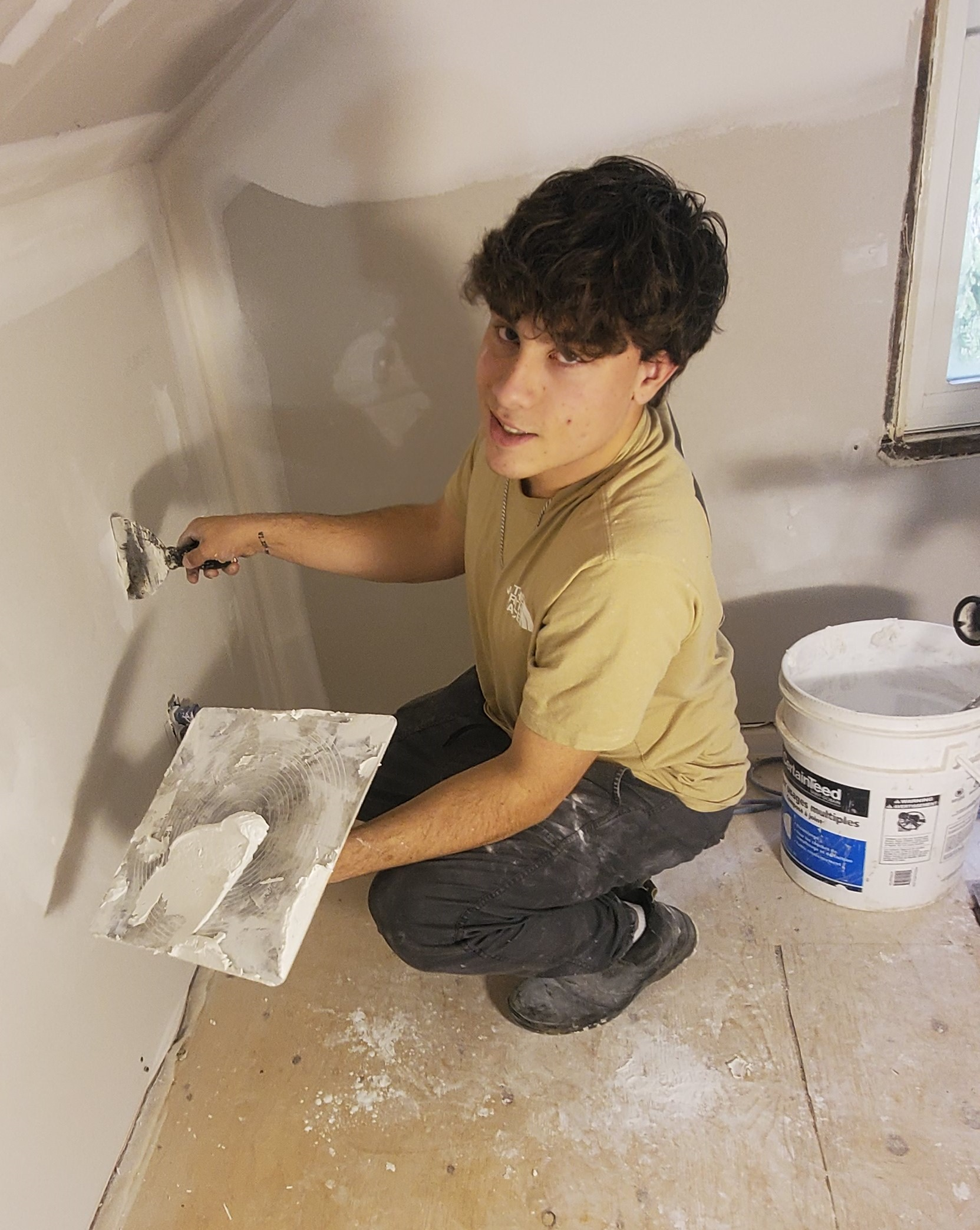 student working on drywall at his co-op employment