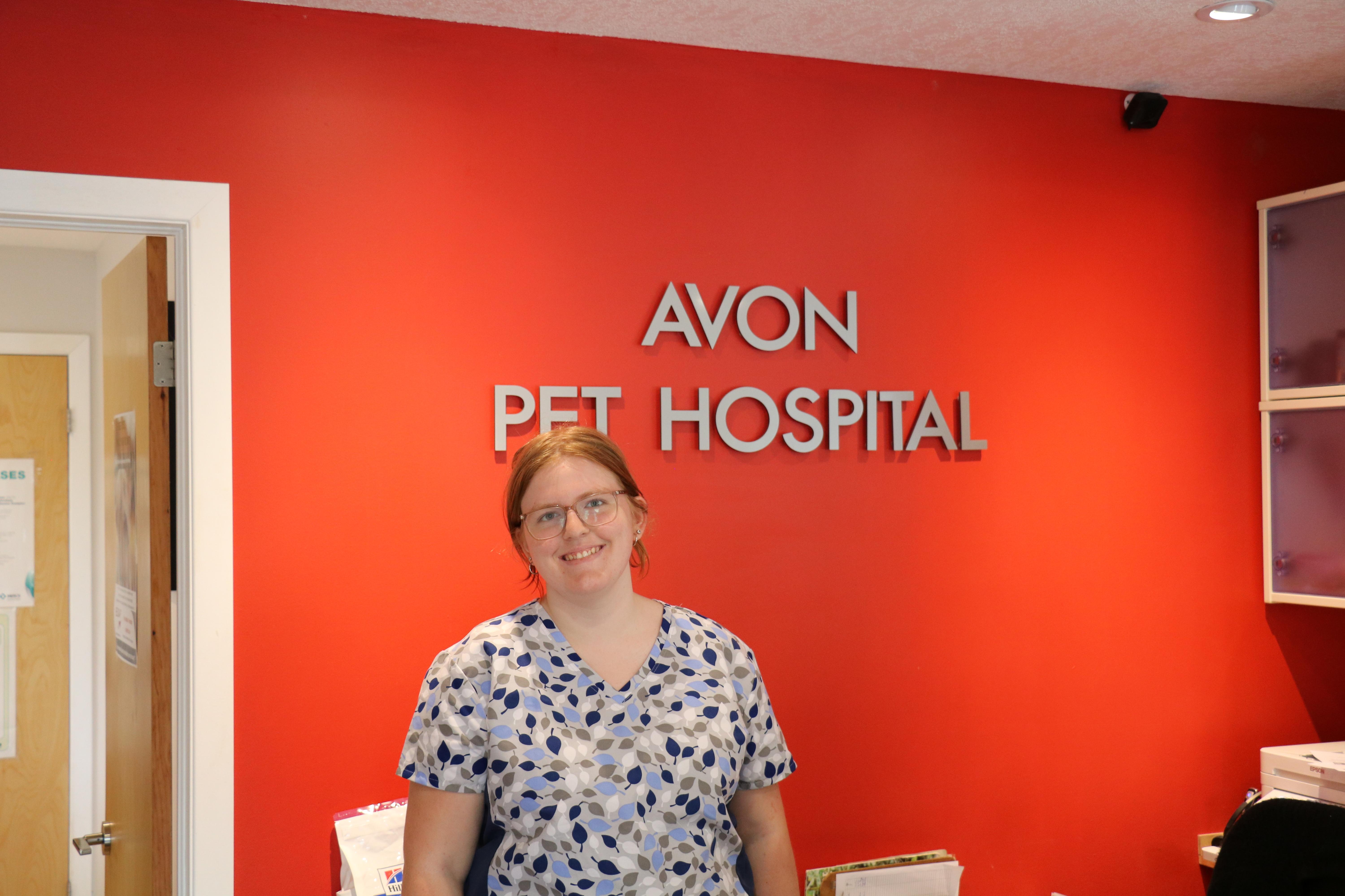 student in front of Avon Pet Hospital sign