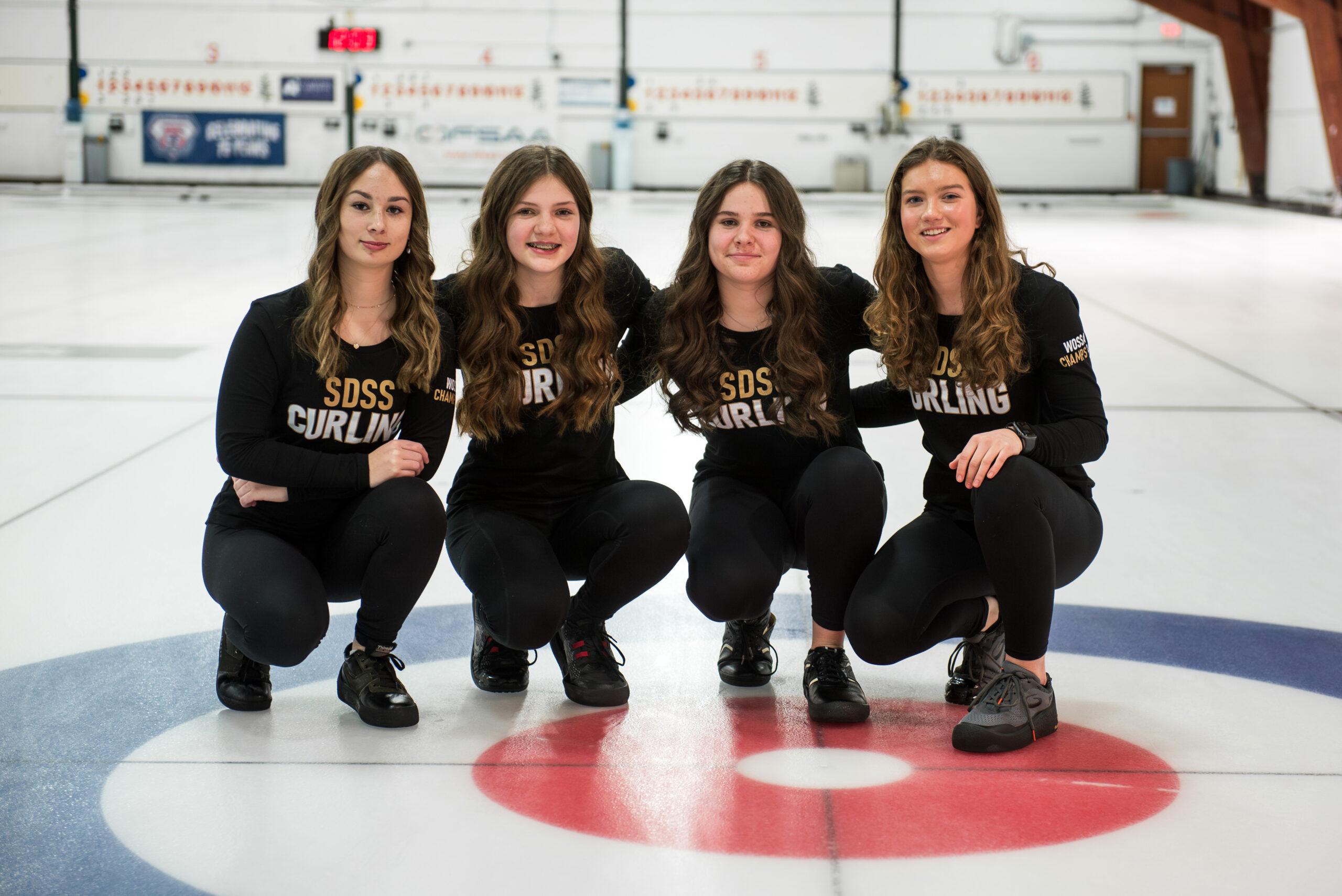 girls curling team posing on rink