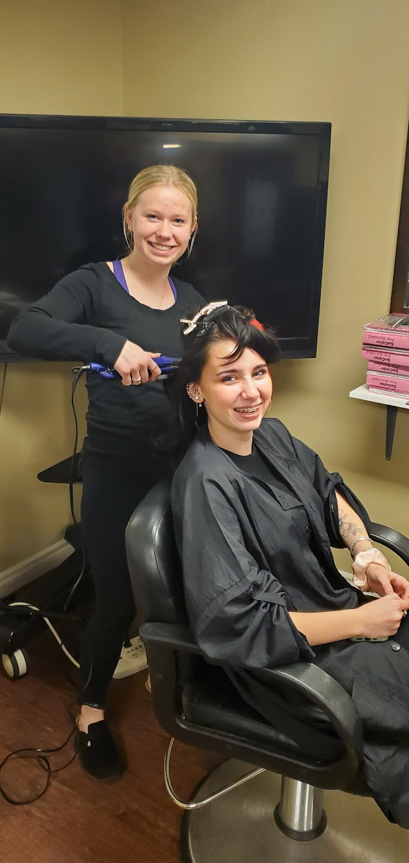 student cutting a client's hair at her co-op