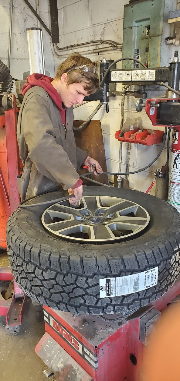 student working on a tire