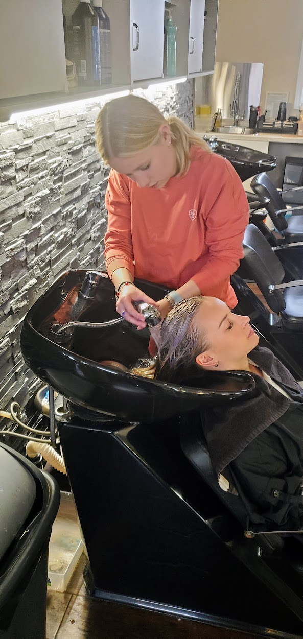 student washing a client's hair in the salon